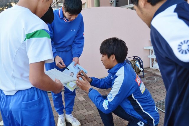 サッカー部員以外の生徒らにもサインを求められ、囲まれる田向選手 【写真　米村優子】