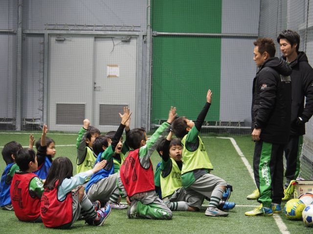 元気に手を上げる子どもたち。左から、桜井直人とアシスタントコーチの佐々木竜太。
